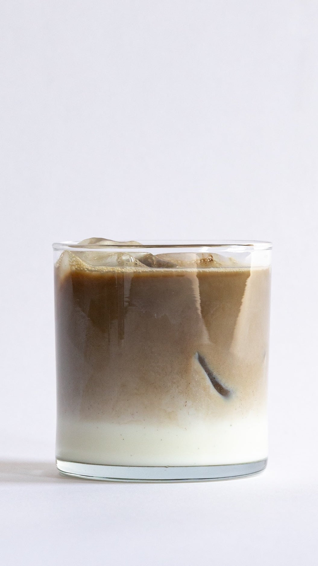 iced hojicha latte in a clear glass cup