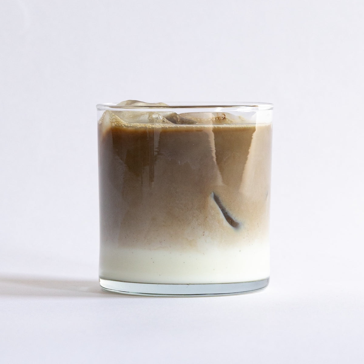 Glass of iced hojicha with a white background