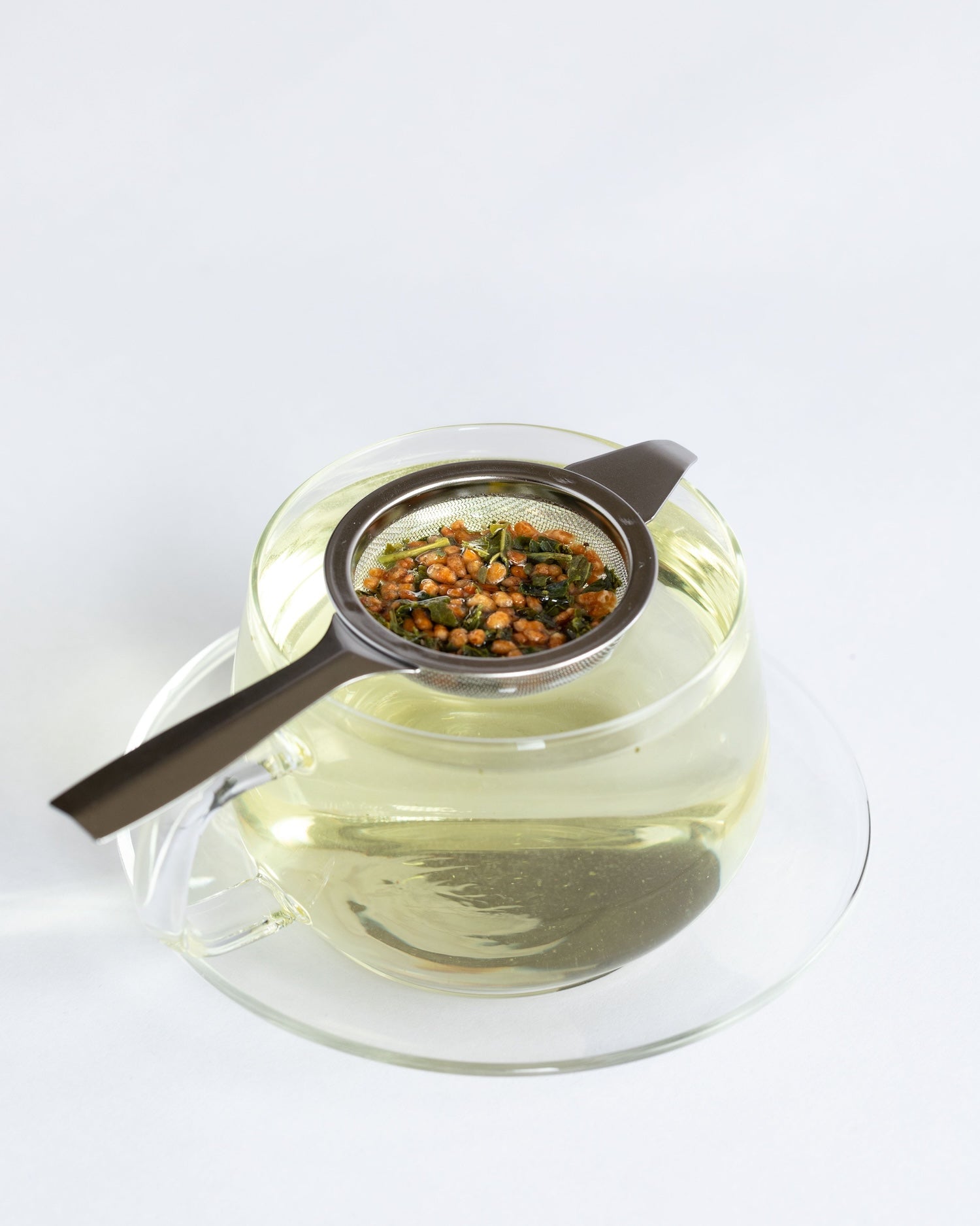 single serving of genmaicha green tea in a clear tea cup