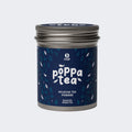 A tin container of PoppaTea Hojicha Tea Powder with a blue label featuring Japanese characters and decorative patterns.