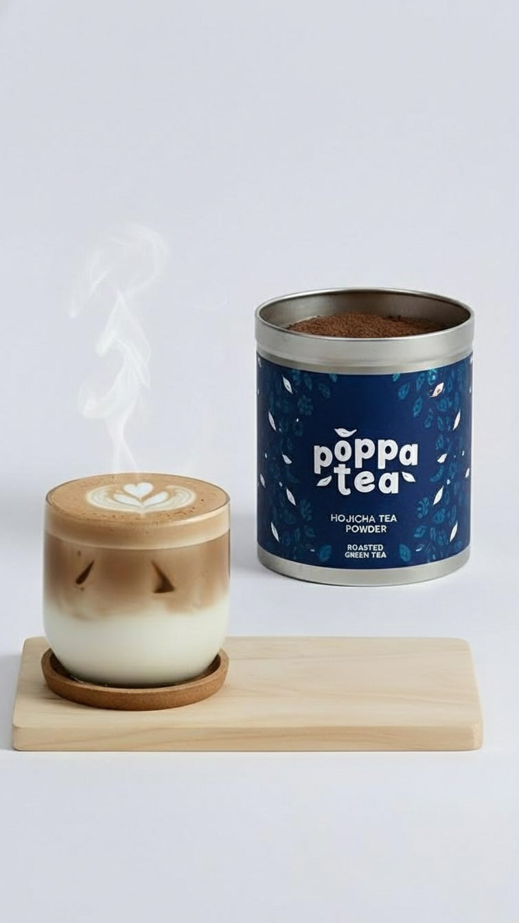 hot hojicha latte steaming from a cup with a tin of poppa tea hojicha power in the background