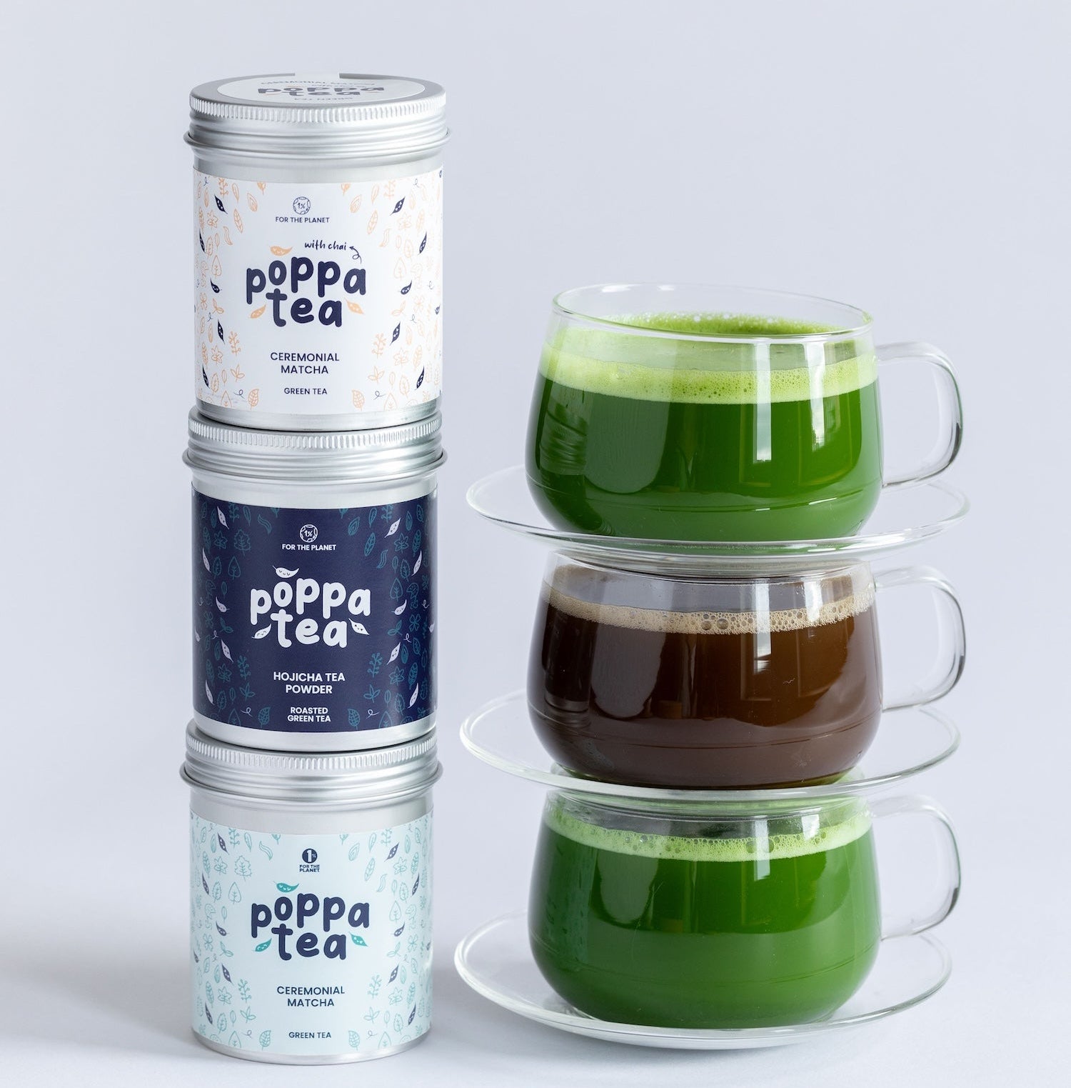 Three stacked silver metal tea tins labeled 'poppa tea' beside three stacked clear glass cups containing green, brown, and green tea, on a light gray background.