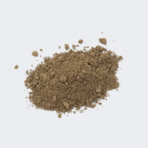 loose dark roasted hojicha tea powder opn a white background
