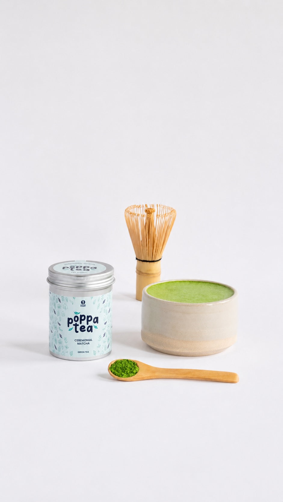 hot matcha latte in a matcha bowl. Next to tin of popptea matcha and bamboo whisk
