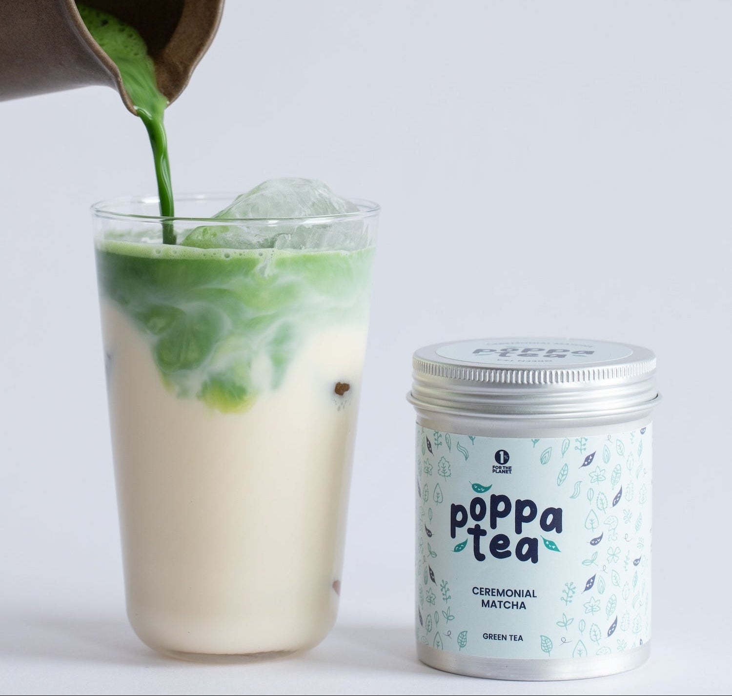matcha Green tea being poured into a glass with a can of Poppa Tea on a light background