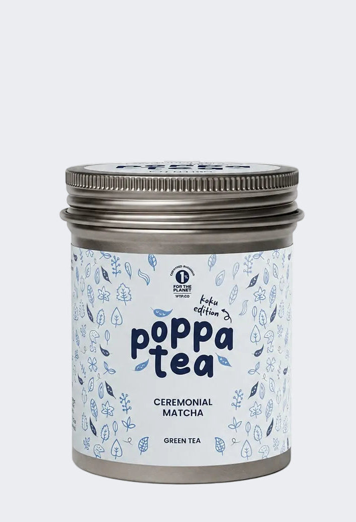 A silver metal tin of Poppa Tea Ceremonial Matcha Green Tea (koku edition), featuring a light blue and white patterned label with dark blue text, set against a plain white background.