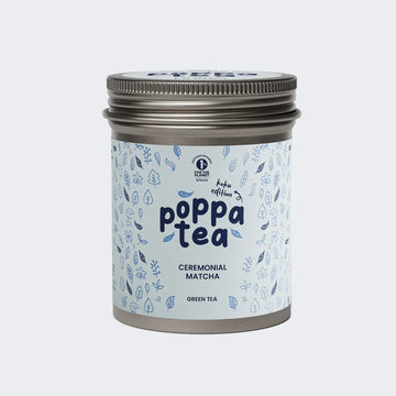 A tin of Poppa Tea ceremonial matcha green tea koku edition, featuring a light blue label with blue leaf illustrations and a metallic silver lid,