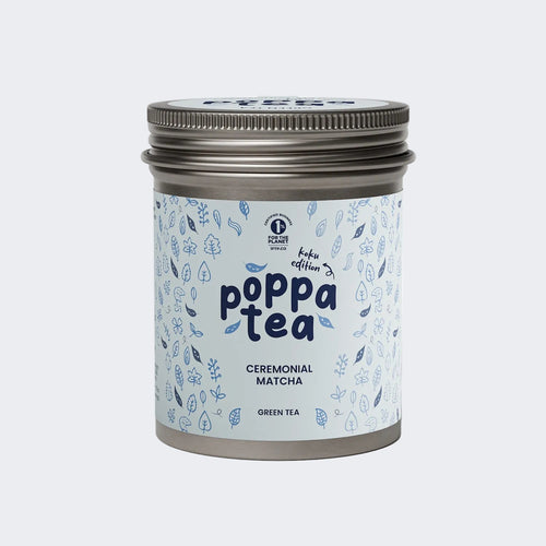 A tin of Poppa Tea ceremonial matcha green tea koku edition, featuring a light blue label with blue leaf illustrations and a metallic silver lid,