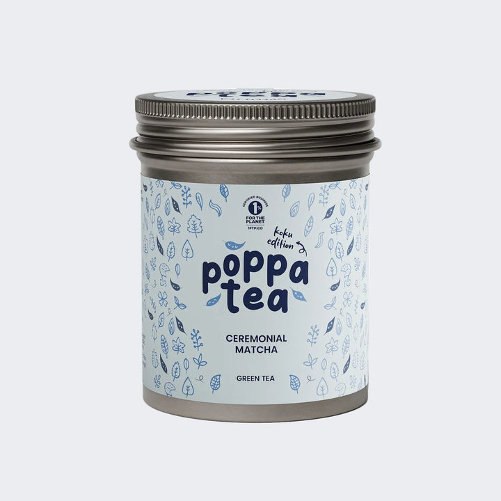 A tin of Poppa Tea ceremonial matcha green tea koku edition, featuring a light blue label with blue leaf illustrations and a metallic silver lid,