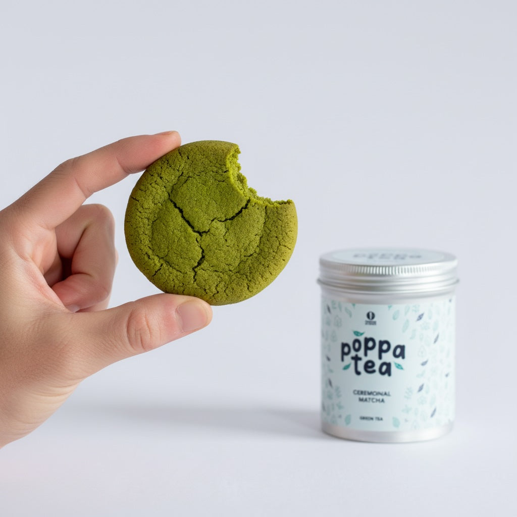 green matcha tea cookie with a bite missing and next to a tin of Poppa Tea matcha