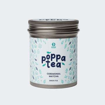 A tin container of Poppatea Ceremonial Matcha Green Tea with a blue and green floral pattern on the label.