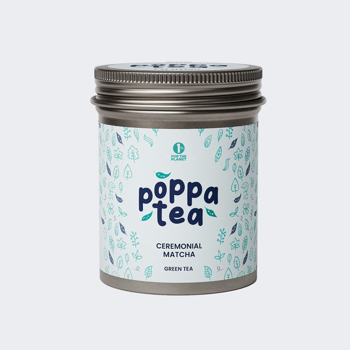 A tin container of Poppatea Ceremonial Matcha Green Tea with a blue and green floral pattern on the label.